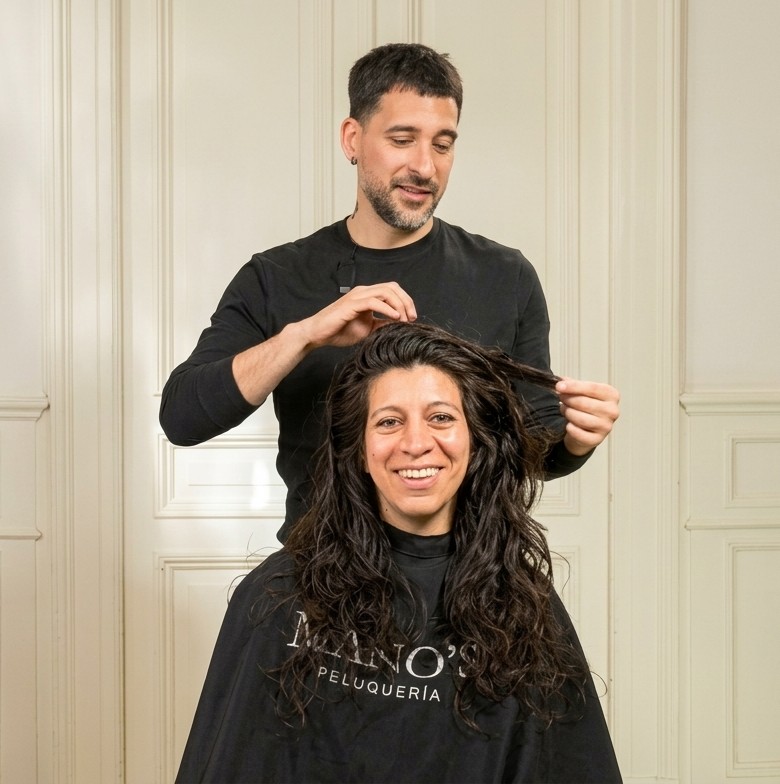 Leandro Reismann trabajando el cabello de una clienta en Mano's